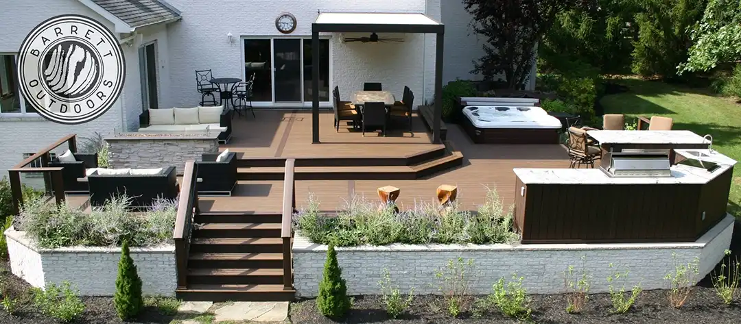 Photo of a multi-level deck with outdoor kitchen, hot tub, pergola, and outdoor dining room, plus built-in planters.