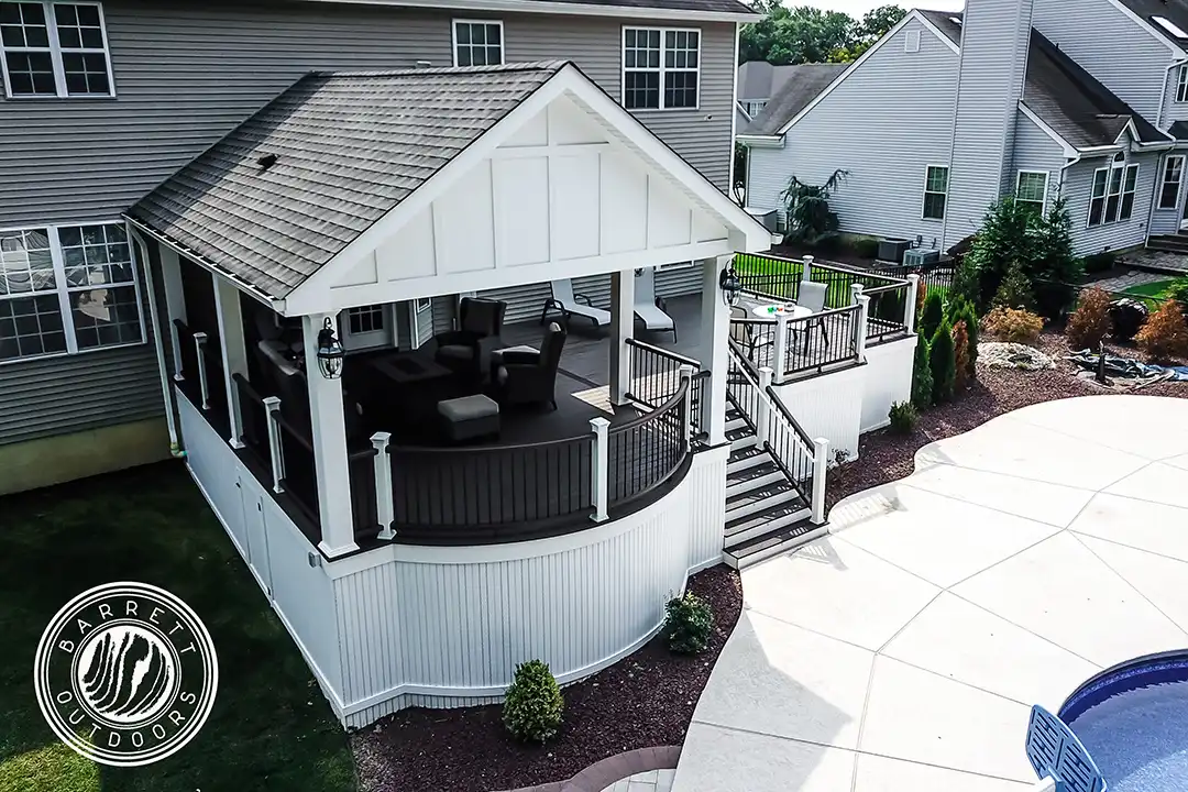 Photo of a covered curved deck with steps and deck railing.