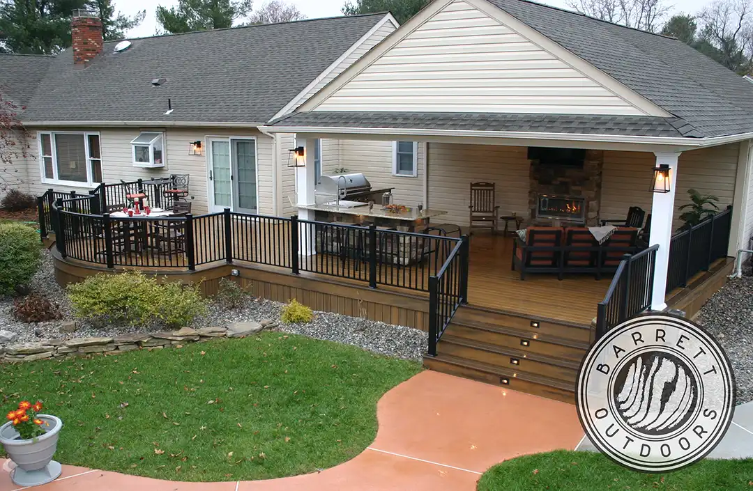 Photo of a custom deck featuring a covered deck area and a curved deck area with black railing and lights recessed into the steps.