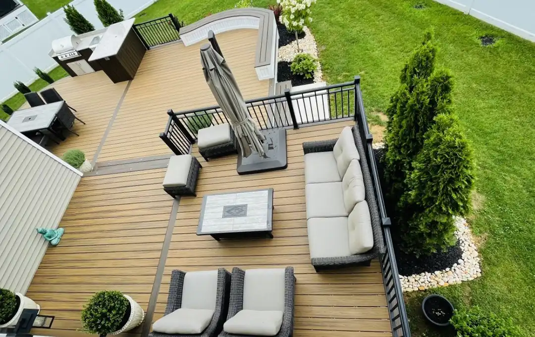 Photo of an award-winning multi-level deck with railing, outdoor furniture, and an outdoor kitchen and dining area.