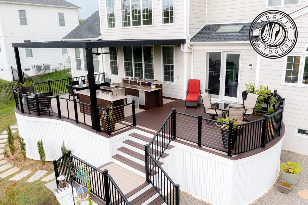 Photo of an award-winning curved deck with an outdoor kitchen and areas for outdoor dining and relaxation.