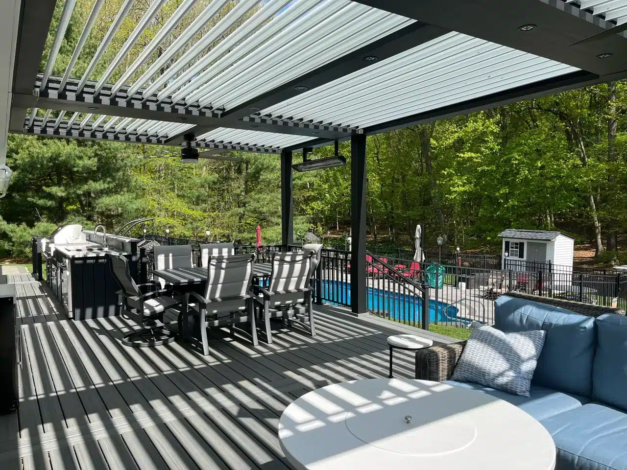 modern motorized pergola covering a deck and outdoor kitchen