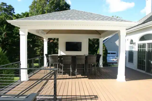 Photo of a composite deck with a covered entertainment and dining area with cable railing